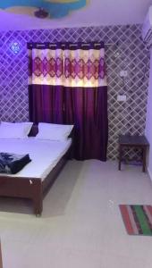 a bedroom with a bed and a purple curtain at Nhyn home stay in Varanasi