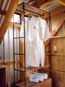 a white shirt hanging on a rack in a cabin at Casa 1800 Los Naranjos Boutique Hotel in Los Naranjos
