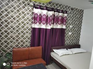 a bedroom with a bed and a purple curtain at Nhyn home stay in Varanasi +1 photo