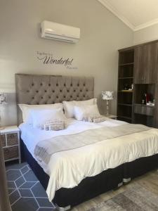 a large bed with white sheets and pillows at C-Vu-Cottage cosy and warm private apartment in Mossel Bay