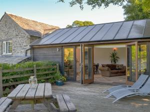 a conservatory with sliding glass doors and a table and chairs at Wallhouse Barn in Blisland