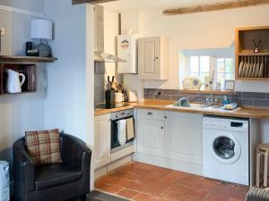 a kitchen with a sink and a washing machine at Melrose Cottage in Cromer