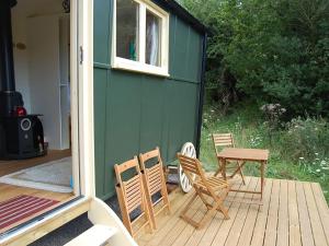 eine Terrasse mit Stühlen, einem Tisch und einem Haus in der Unterkunft Hicks Hut -ukc4753 in Tremeirchion