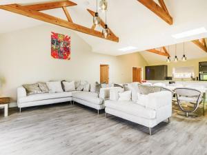 a living room with two white couches and a kitchen at The Gallery Barn - Uk39368 in Swafield