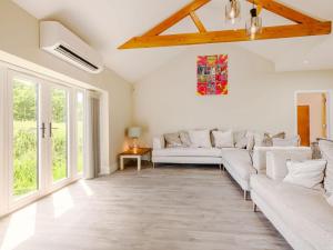 a living room with white furniture and large windows at The Gallery Barn - Uk39368 in Swafield