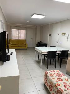 sala de estar con sofá, mesa y sillas en en Nueva Córdoba alojamiento para 3 personas en Córdoba