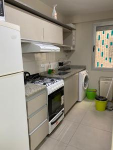cocina con fogones y lavavajillas en en Nueva Córdoba alojamiento para 3 personas en Córdoba