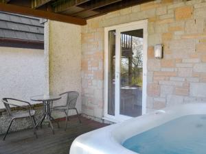 a hot tub on a patio with a table and chairs at Valley Lodge 47 - Ukc2779 in Gunnislake