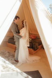 eine Braut und ein Bräutigam stehen in einem Zelt in der Unterkunft Zion Glamping Adventures in Hildale