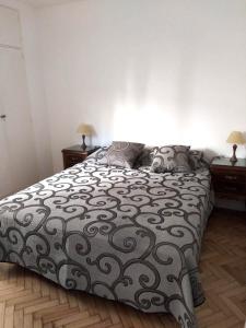 1 dormitorio con 1 cama con edredón blanco y negro en Departamento muy luminoso en el centro para 3 personas en Buenos Aires