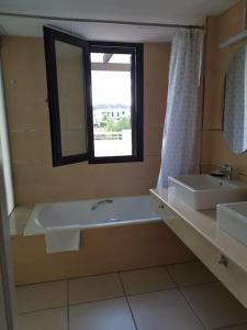 uma casa de banho com uma banheira, um lavatório e um espelho. em Casa Apartamento Mojacar Macenashome em Mojácar