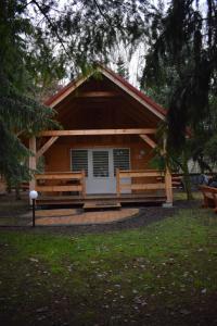 a cabin with two benches in front of it at Ranczo Targówka in Malanów
