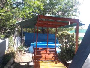 cenador con piscina azul en el patio trasero en Cabaña en las sierras de Cosquín PB en Cosquín
