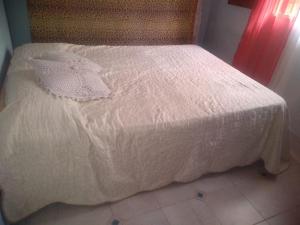 Una cama blanca con un edredón blanco. en Cabaña en las sierras de Cosquín PB en Cosquín