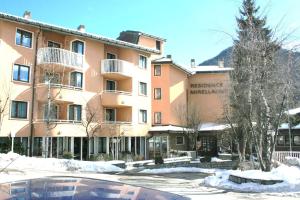 a large apartment building with a pool in front of it at Residence Mirelladue in Ponte di Legno