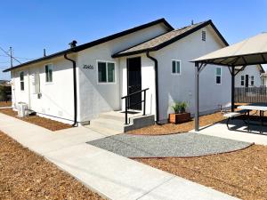 a white house with a table and a patio at Country Living-harrison Ranchhr3 in Visalia