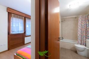 y baño con cama, aseo y ducha. en Apartamento Mirador Playa de Barro, en Barro de Llanes