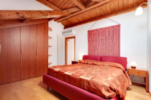 una camera con un grande letto e un divano rosso di Little Canal 14 a Venezia