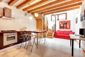 una cucina e un soggiorno con divano rosso di Little Canal 14 a Venezia