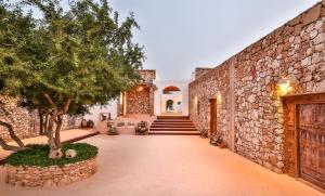 an exterior view of a building with a stone wall at Tasguayan Maison de Charme in Borj
