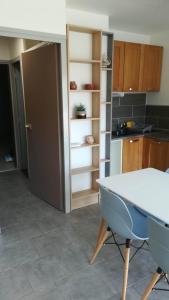 een keuken met een tafel en stoelen in een kamer bij Beau studio cabine avec balcon, vue piscine, parking privé, climatisation, solarium, laverie in Cap d'Agde