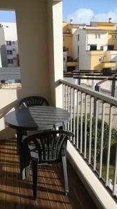 een zwarte tafel en stoelen op een balkon bij Beau studio cabine avec balcon, vue piscine, parking privé, climatisation, solarium, laverie in Cap d'Agde