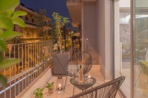 a balcony with two chairs and a table with a bottle of wine at Living Stone Bronze in Athens