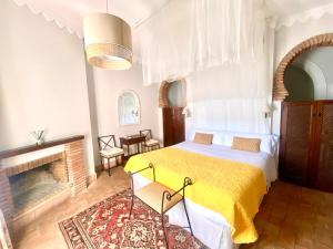 1 dormitorio con 1 cama y chimenea en El Rincón de las Descalzas, en Carmona
