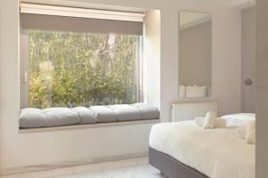 a bedroom with two beds and a window at Living Stone Bronze in Athens