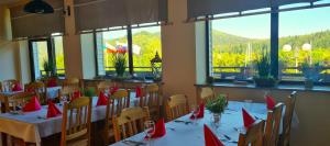 a dining room with tables and chairs with red napkins at Ośrodek Perełka Bieszczady in Cisna