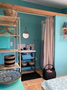 une chambre avec des murs bleus et une étagère avec des paniers dans l'établissement Les cabanons de l'Oliveraie, à Pernes-les-Fontaines