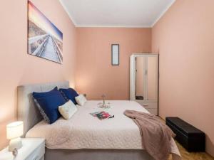 a bedroom with a large bed with blue pillows at Apartman KARESA -Rijeka in Rijeka