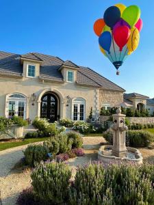 a balloon is flying in front of a house at Domaine Chardonnay in Temecula