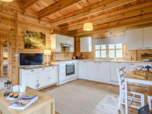 a kitchen with white cabinets and a wooden ceiling at Halfmoon Wood - Ukc2194 in Caunton