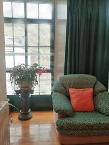 a green chair with a red pillow in a room with windows at Casa Licerio in Samos