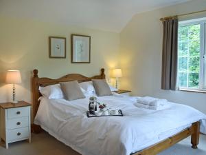 a bedroom with a large white bed with a tray on it at Cornant in Llechryd