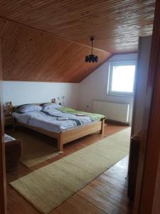 a bedroom with a bed with a wooden ceiling at Kupres Desktop - mountain house in Kupres
