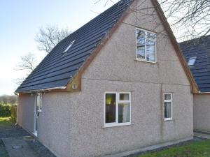 una casa con techo negro y 2 ventanas en Dartmoor 3, en Gunnislake