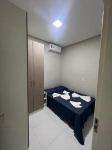 Habitación pequeña con cama azul y toallas. en - Apartamento cânion - Pousada cânion en Canindé de São Francisco