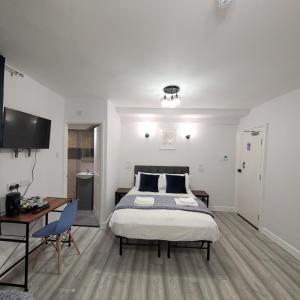 a bedroom with a bed and a desk and a tv at Argyle Square Hotel in London