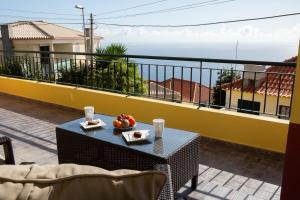 un tavolo con un cesto di frutta sul balcone di Casa Madeira a Santa Cruz