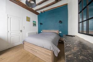 - une chambre avec un lit et un mur bleu dans l'établissement Angers Hyper Centre - Rue St Laud, 2min Ralliement, à Angers