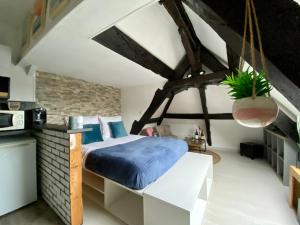 een slaapkamer met een bed en een bakstenen muur bij Mon Saint-Martin - APPART’HOTEL - Cœur de Bayeux in Bayeux