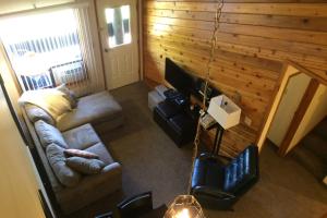 a living room with a couch and a television at The Griz Inn by Park Vacation Management in Fernie