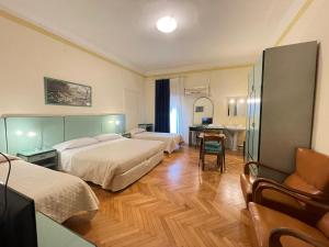 a hotel room with two beds and a desk at Hotel Panorama Bologna Centro in Bologna