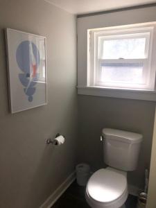 a bathroom with a white toilet and a window at Chic Retreat in Downtown St Augustine in Saint Augustine