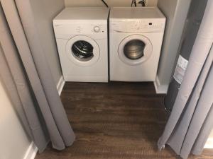 a washer and dryer in a laundry room with curtains at Chic Retreat in Downtown St Augustine in St. Augustine