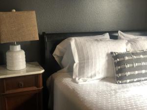 a bed with white pillows and a lamp on a night stand at Chic Retreat in Downtown St Augustine in Saint Augustine