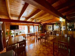a dining room with wooden ceilings and tables and chairs at La Cabaña in Neltume