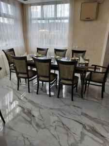 ein Esszimmer mit einem Tisch und Stühlen auf einem Marmorboden in der Unterkunft JOKSIM Rooms&Restaurant in Kuršumlija